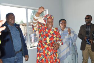 Deputy Prime Minister Thulisile Dladla hands over house keys to Gogo Khumbulile Dlamini in Mpolonjeni, one of four beneficiaries of newly built homes in the Hhohho region. Looking on are Motshane MP Wilton Nkambule and NDMA officials.