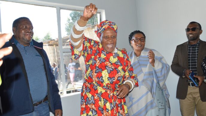 Deputy Prime Minister Thulisile Dladla hands over house keys to Gogo Khumbulile Dlamini in Mpolonjeni, one of four beneficiaries of newly built homes in the Hhohho region. Looking on are Motshane MP Wilton Nkambule and NDMA officials.