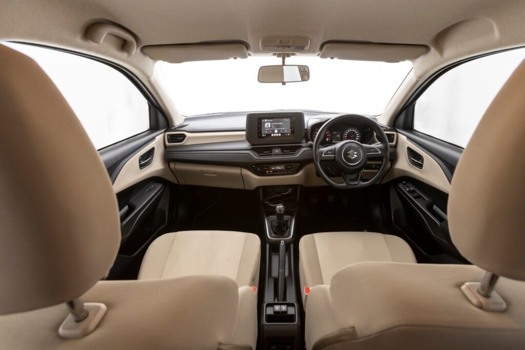 Inside the DZire: A modern cabin featuring a 7-inch infotainment system, digital air controls, and USB ports for convenient everyday driving.