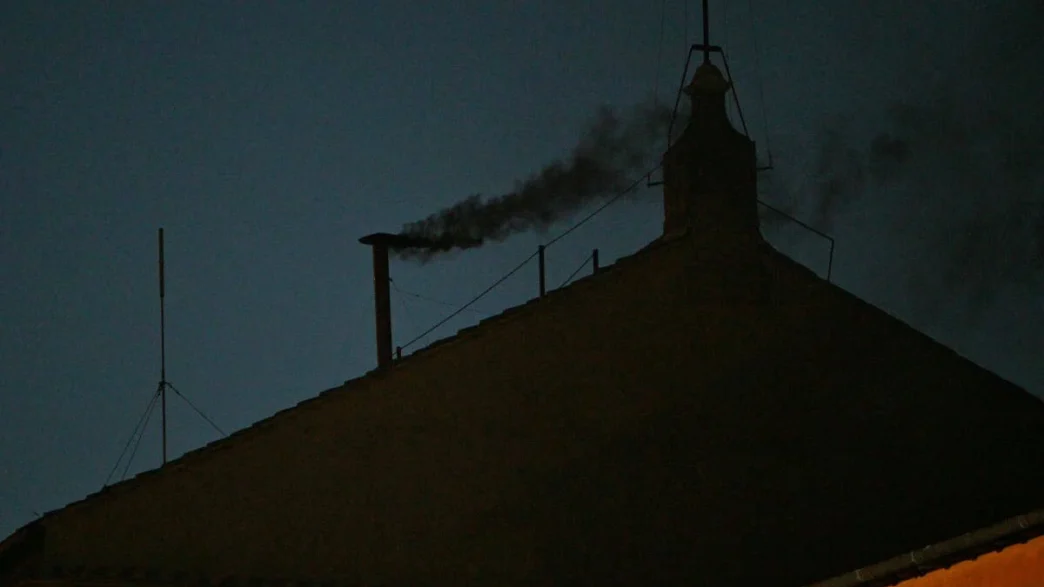 This photograph shows black smoke rising from the chimney of the Sistine Chapel signalling that cardinals failed to elect a new pope in the first ballot of their conclave in the Vatican on May 7, 2025. (Photo by Andreas SOLARO / AFP)