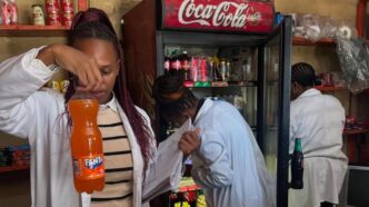 Health inspectors examine the expiry date on a bottled drink during a joint operation in Msunduza, while other officials inspect shelf items for compliance in the background. Photo: Municipal Council Of Mbabane