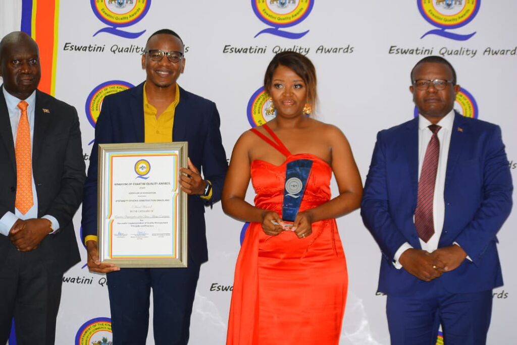 Honourable Manqoba B. Khumalo poses with some of the award winners after presenting honours during the industry awards ceremony in Manzini.