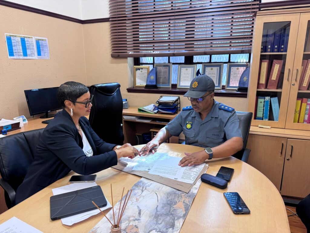 Dereleen James with a police officer at Cape Town Central Police Station following the filing of criminal charges against Minister Gayton McKenzie.