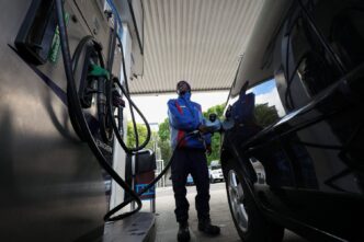 A worker fills a car at a petrol station in Cape Town, South Africa, March 25, 2026. REUTERS/Esa Alexander
