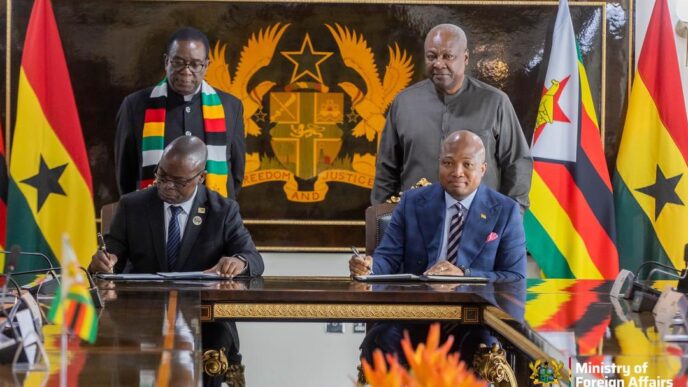 Presidents John Dramani Mahama of Ghana and Emmerson D. Mnangagwa of Zimbabwe stand behind their respective Foreign Affairs Ministers during the signing ceremony in Accra.