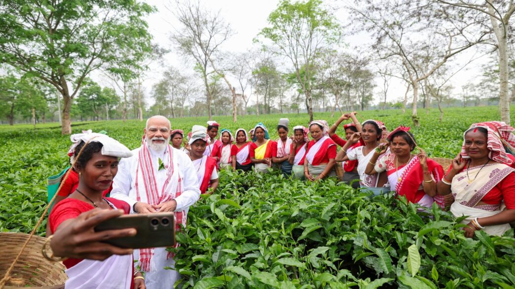 PM Narendra Modi interacts with women workers at a tea garden in Dibrugarh, Assam, taking a selfie during his visit.