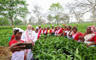 PM Narendra Modi interacts with women workers at a tea garden in Dibrugarh, Assam, taking a selfie during his visit.