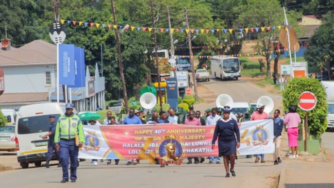 Community members, the Correctional Services Band and drum majorettes from St. Mary's Lobamba fill the streets of Pigg's Peak during the 40 Years of Reign Roadshow celebrating His Majesty King Mswati III's four decades on the throne, organised by the Ministry of Home Affairs in partnership with Pigg's Peak Town Council. Photo: Supplied
