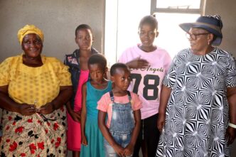 Deputy Prime Minister Thulisile Dladla pictured with beneficiary families during the official handover of three newly built homes at Bulandzeni, Ndzingeni Inkhundla, financed by the Roman Catholic Church through Caritas