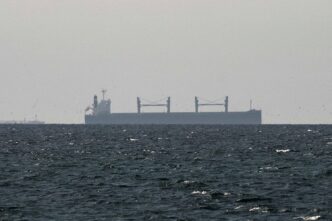 A cargo ship in the Gulf, near the Strait of Hormuz, as seen from northern Ras al-Khaimah, near the border with Oman’s Musandam governance, amid the U.S.-Israeli conflict with Iran, in United Arab Emirates, March 11, 2026. REUTERS/Stringer/File Photo