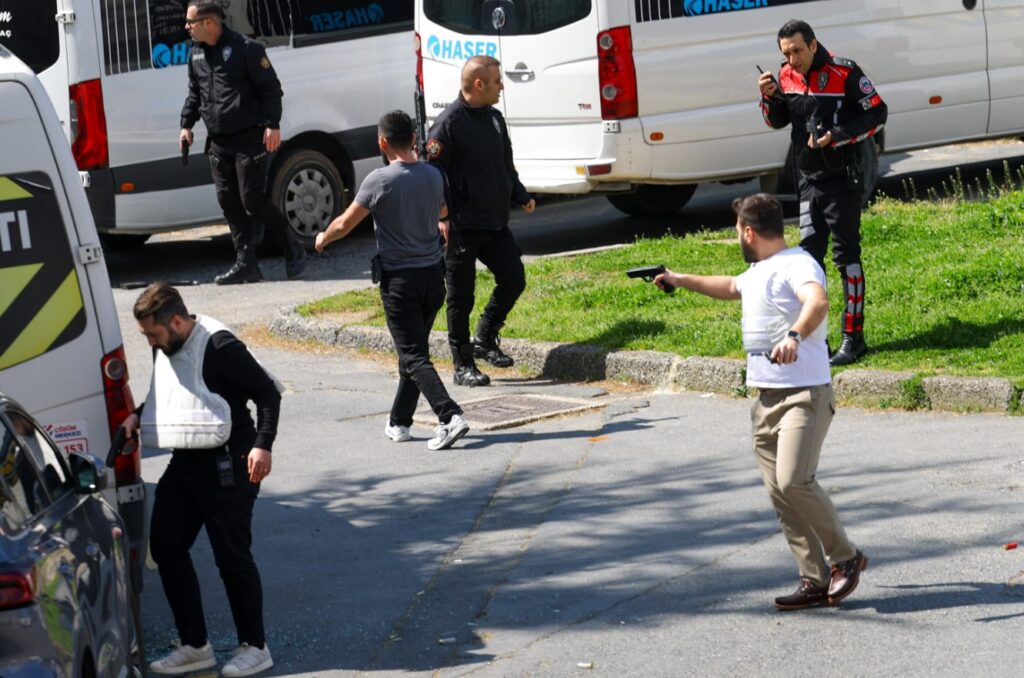 A man holds a gun, after gunfire was heard near the building housing the Israeli consulate, according to a witness, in Istanbul, Turkey, April 7, 2026 [Murad Sezer/Reuters]