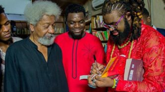 Nigerian author and filmmaker Onyeka Nwelue signs a copy of his book "The Beginning of Everything Colorful" for Nobel Laureate Wole Soyinka,