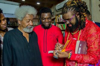 Nigerian author and filmmaker Onyeka Nwelue signs a copy of his book "The Beginning of Everything Colorful" for Nobel Laureate Wole Soyinka,