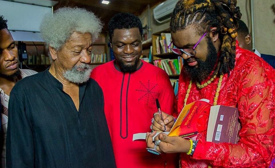 Nigerian author and filmmaker Onyeka Nwelue signs a copy of his book "The Beginning of Everything Colorful" for Nobel Laureate Wole Soyinka,