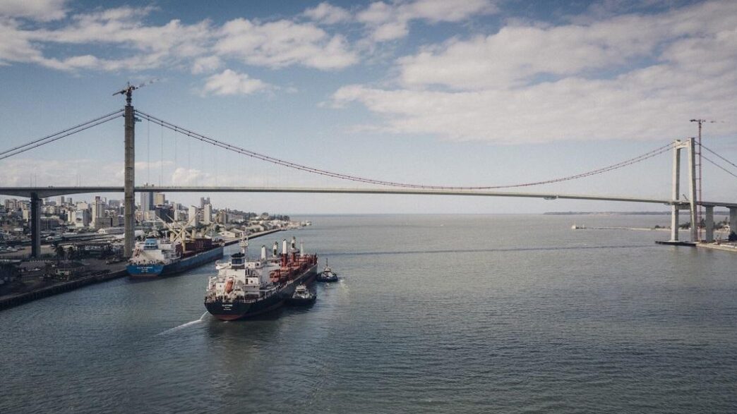 A cargo vessel navigates the waters off Maputo with the iconic Maputo-Katembe Bridge visible in the background