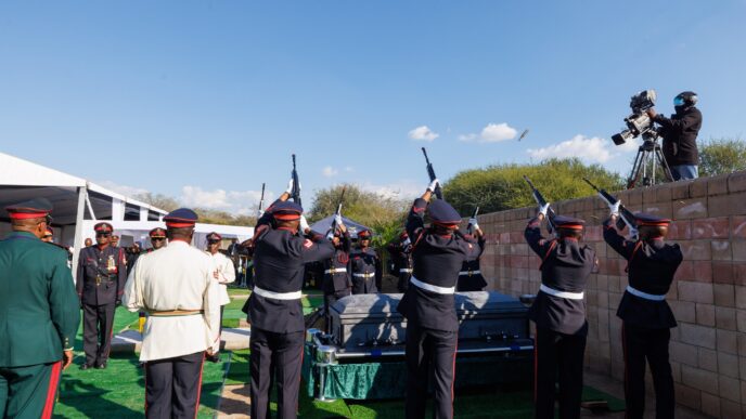 Soldiers fire a salute as the coffin of former Botswana President Festus Gontebanye Mogae is lowered to rest at Phomolong Cemetery in Gaborone during a state burial conducted with full military honours.