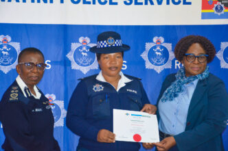 A Royal Eswatini Police Service officer receives a certificate of completion from Deputy National Commissioner of Police Ms. Bonsile Masuku during the closing ceremony of the Quality Service Delivery, Customer Care and Records Management training courses. Photo by REPS