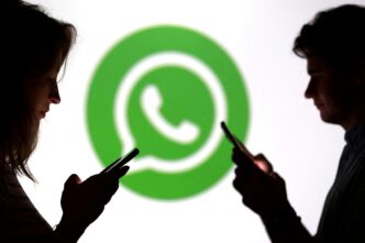 Teenagers pose for a photo while holding smartphones in front of a Whatsapp logo in this illustration taken September 11, 2025. REUTERS/Dado Ruvic/Illustration/File Photo