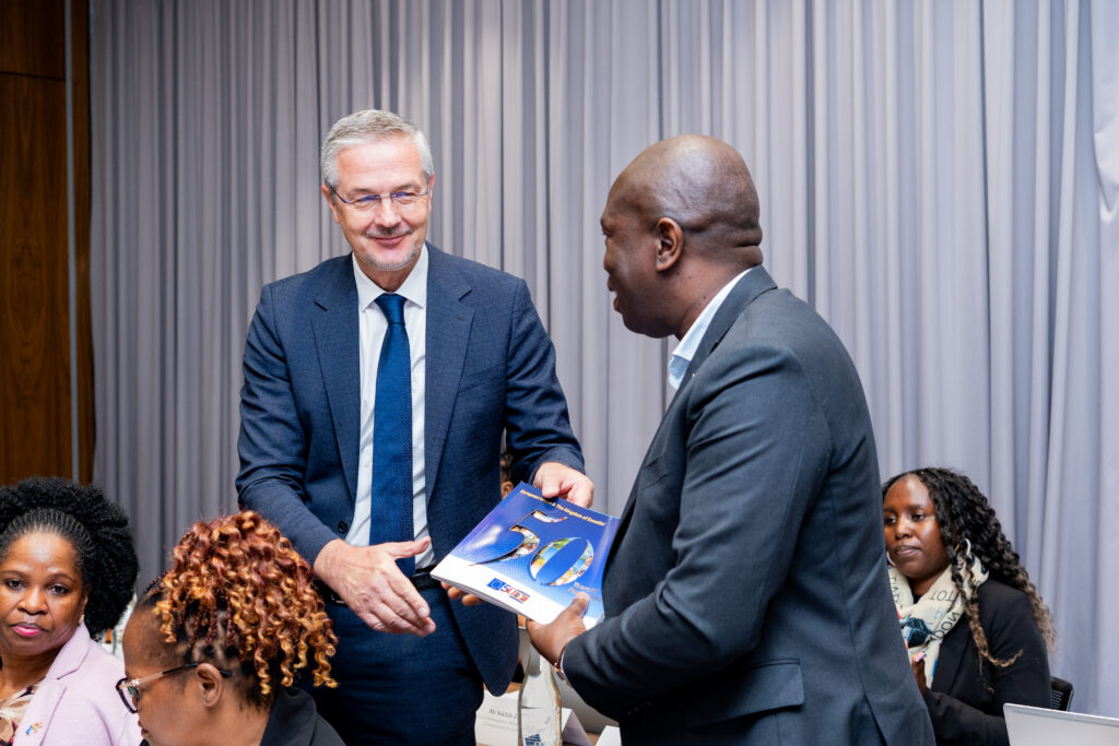 EU Ambassador H.E. Karsten Mecklenburg presents a commemorative booklet marking 50 years of EU partnership to Principal Secretary of the Ministry of Commerce, Industry and Trade Melusi Masuku during the 3rd Eswatini-EU Partnership Dialogue in Mbabane. Photo by Phindokuhle Sithole/Lokuhle Media