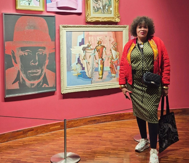 Photo: Maria McCloy pictured at a gallery, exuding the style and cultural flair she was celebrated for throughout her career. | Photo credit: Facebook