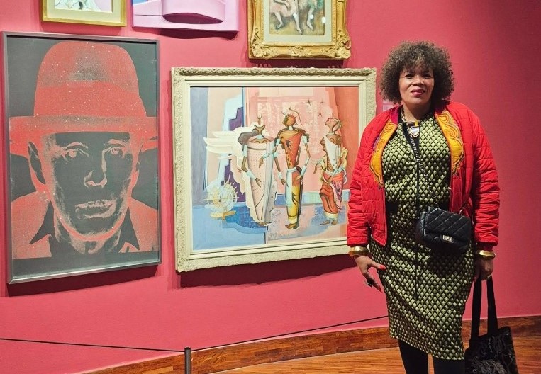 Photo: Maria McCloy pictured at a gallery, exuding the style and cultural flair she was celebrated for throughout her career. | Photo credit: Facebook