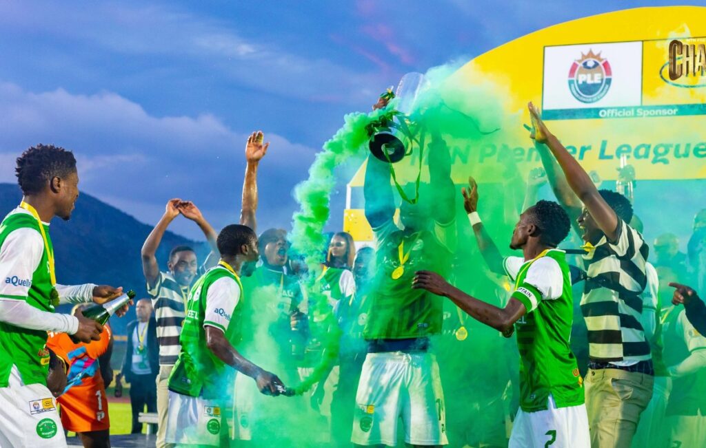 Nsingizini Hotspurs players celebrate with the trophy at Somhlolo National Stadium on Sunday, 24 May 2026, as green smoke fills the air around them