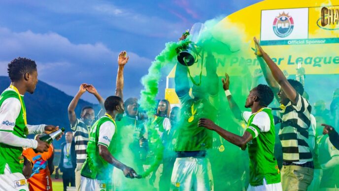 Nsingizini Hotspurs players celebrate with the trophy at Somhlolo National Stadium on Sunday, 24 May 2026, as green smoke fills the air around them