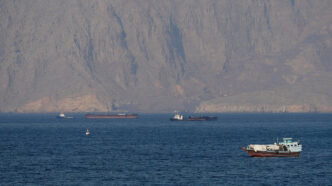US military vessels escort commercial ships through the Strait of Hormuz on Monday