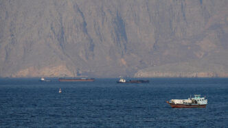 US military vessels escort commercial ships through the Strait of Hormuz on Monday