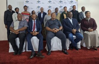 Minister of Labour and Social Security Phila Buthelezi takes pictures with the scholarshi section board.