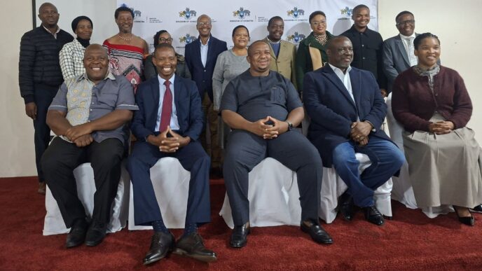 Minister of Labour and Social Security Phila Buthelezi takes pictures with the scholarshi section board.