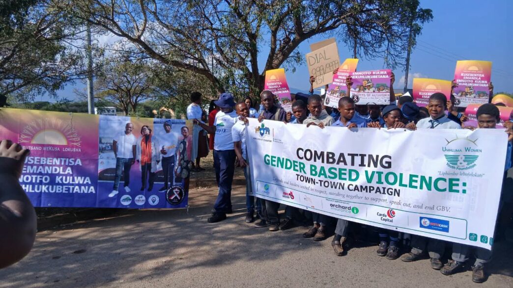 Community members and stakeholders hold up banners during the Gender-Based Violence mini-campaign organised by Lavumisa Police and relevant stakeholders. (Photo: REPS)