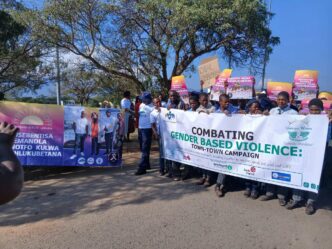 Community members and stakeholders hold up banners during the Gender-Based Violence mini-campaign organised by Lavumisa Police and relevant stakeholders. (Photo: REPS)