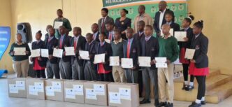 Officials from the Ministry of ICT, His Majesty's Correctional Services and ESCCOM join the 16 learners and newly trained instructors at the handover of the Mobile Phone Repair Laboratory at Vulamasango School.