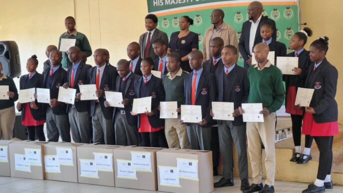 Officials from the Ministry of ICT, His Majesty's Correctional Services and ESCCOM join the 16 learners and newly trained instructors at the handover of the Mobile Phone Repair Laboratory at Vulamasango School.