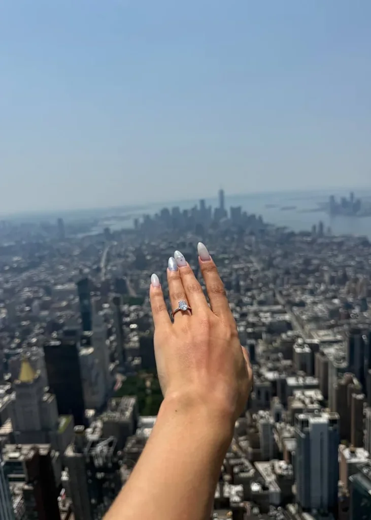 A photo posted on social media by Angela Nikolau on Wednesday shows a ring on her hand after the couple got engaged atop the Empire State Building. From Angela Nikolau