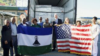 U.S. Chargé d’Affaires Tom Hines and Dr Lucy Mapota with the lenacapavir consignment and the United States and Lesotho flags. Photo: U.S. Embassy Maseru.