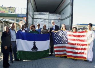U.S. Chargé d’Affaires Tom Hines and Dr Lucy Mapota with the lenacapavir consignment and the United States and Lesotho flags. Photo: U.S. Embassy Maseru.