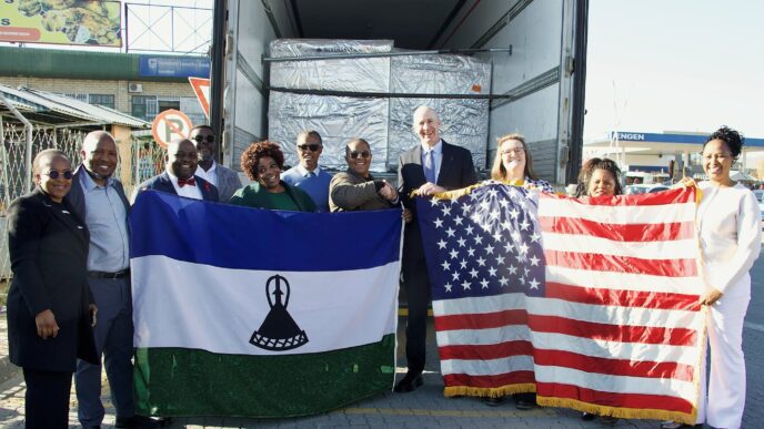 U.S. Chargé d’Affaires Tom Hines and Dr Lucy Mapota with the lenacapavir consignment and the United States and Lesotho flags. Photo: U.S. Embassy Maseru.